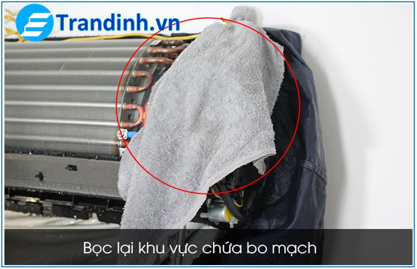 Tiếp đến bạn dùng khăn khô hoặc bọc ni lông để bọc lại khu vực mạch điện trên cục lạnh. Đây là bước cực kỳ quan trọng nhằm tránh tình huống nước văng vào làm chập điện, hư hỏng máy.